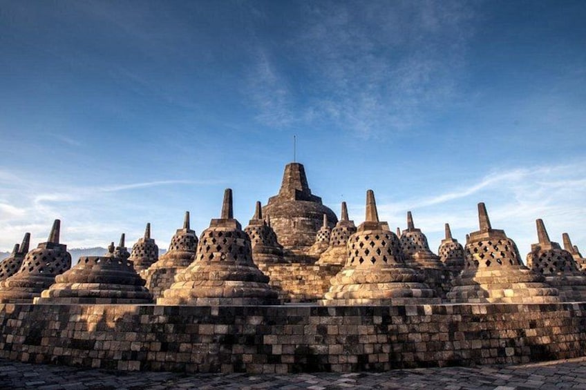 A series of stone structures with conical roofs, arranged in a row. 3