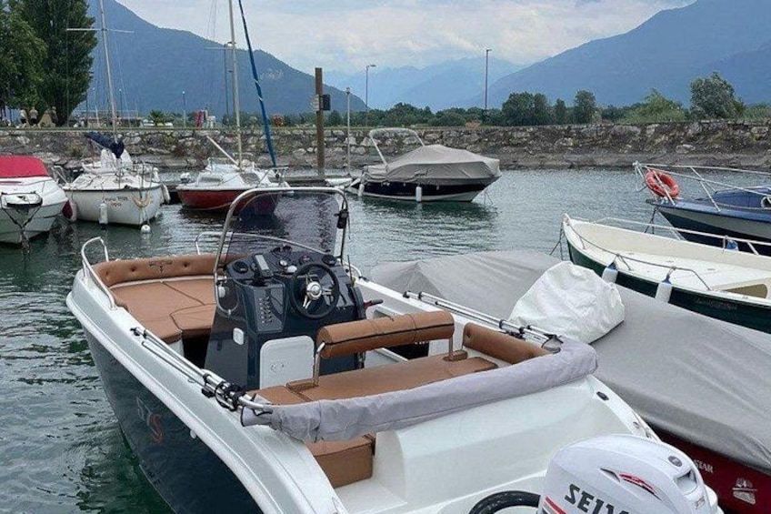 A marina with boats docked, a mountainous landscape in the background, and a clear sky. 2