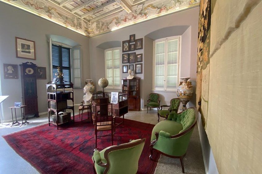 A room with green armchairs, a red carpet, a globe, and a clock. 5