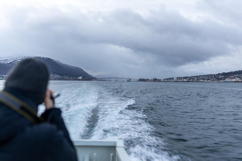 Une personne à bord d’un bateau, un pont et un paysage montagneux. 2