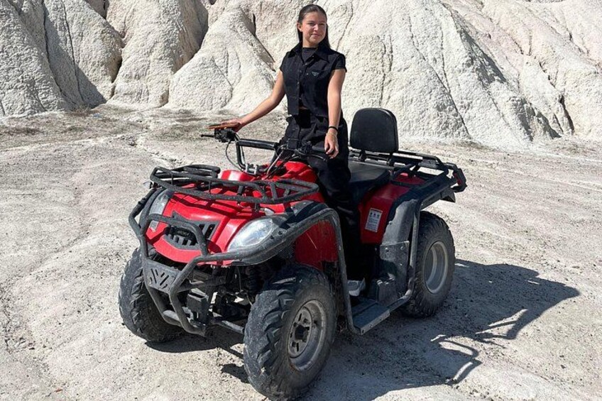 A person on a red ATV in a rocky outdoor area. 3