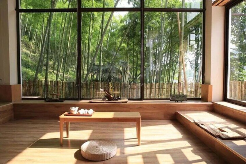 A room with large windows overlooking a bamboo forest. 5