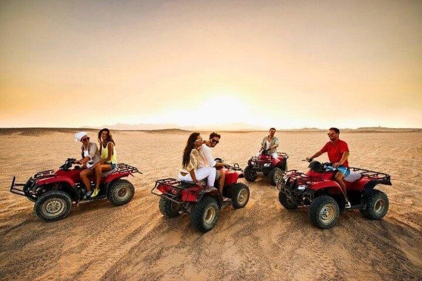 A group of people on ATVs in a desert landscape at sunset. 3