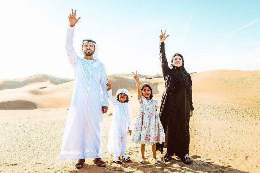 A family in a desert with sand dunes in the background. 3
