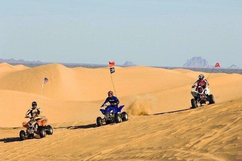 Three off-road vehicles on a sandy dune landscape with flags. 2