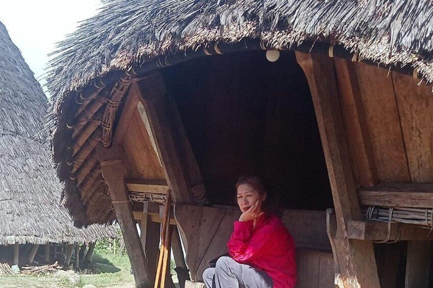 A person sitting in a wooden structure with a thatched roof. 5