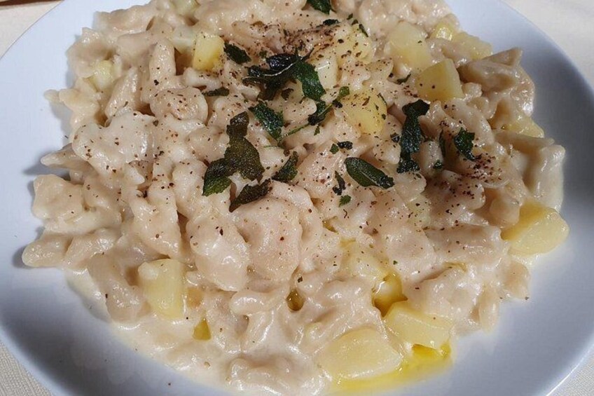 A plate of creamy pasta with herbs and black pepper. 2
