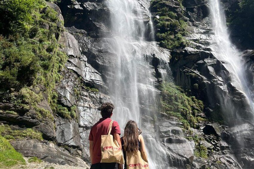 A waterfall with a rocky cliff and greenery. 2