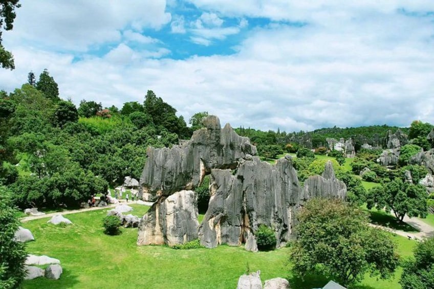 A landscape with prominent rock formations, lush greenery, and a clear sky. 2