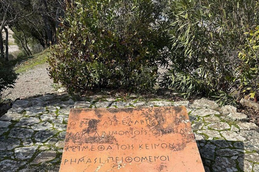 A stone pathway with a weathered plaque in a natural setting. 4