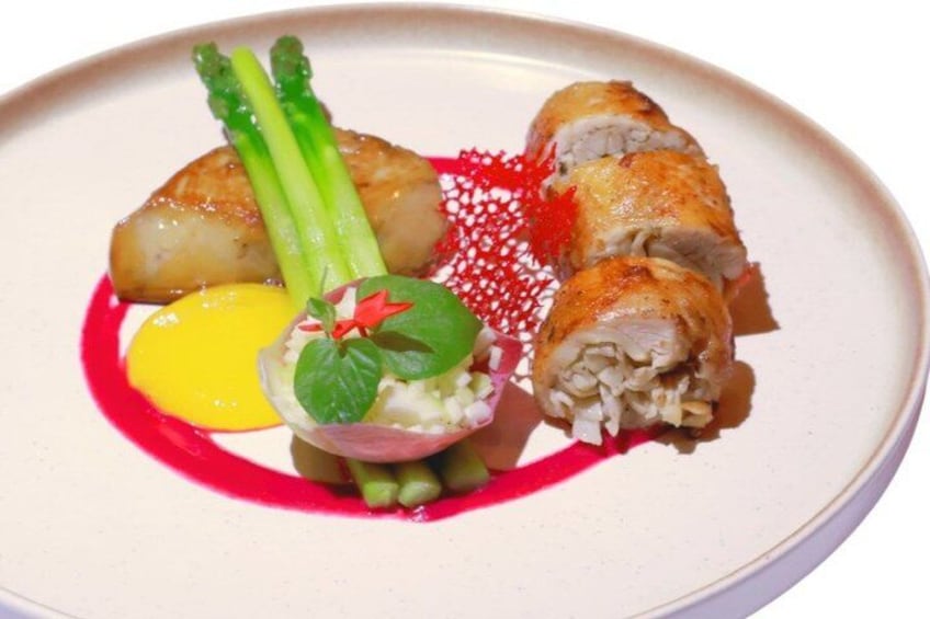 Un plato con rollos de sushi, espárragos, una pequeña porción de salsa y un adorno. 3