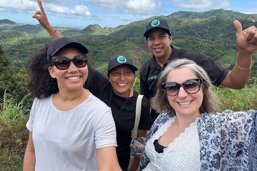 A group of people standing on a hill with a mountainous landscape in the background. 2