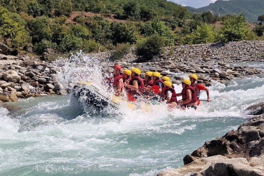 A group of people in a raft navigating a river with rapids. 3