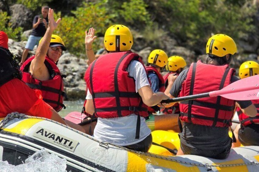 A group of people in yellow helmets and red life vests on a white and yellow raft. 4