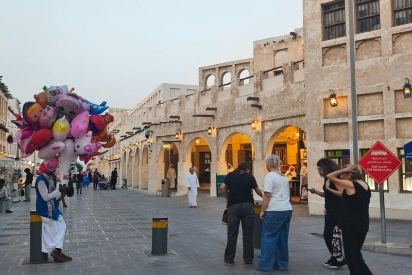 A street with people, a building with arches, and a sign with text. 3