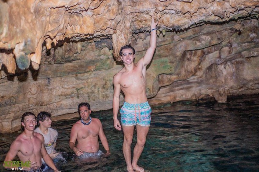 A group of people in a cave with stalactites. 3