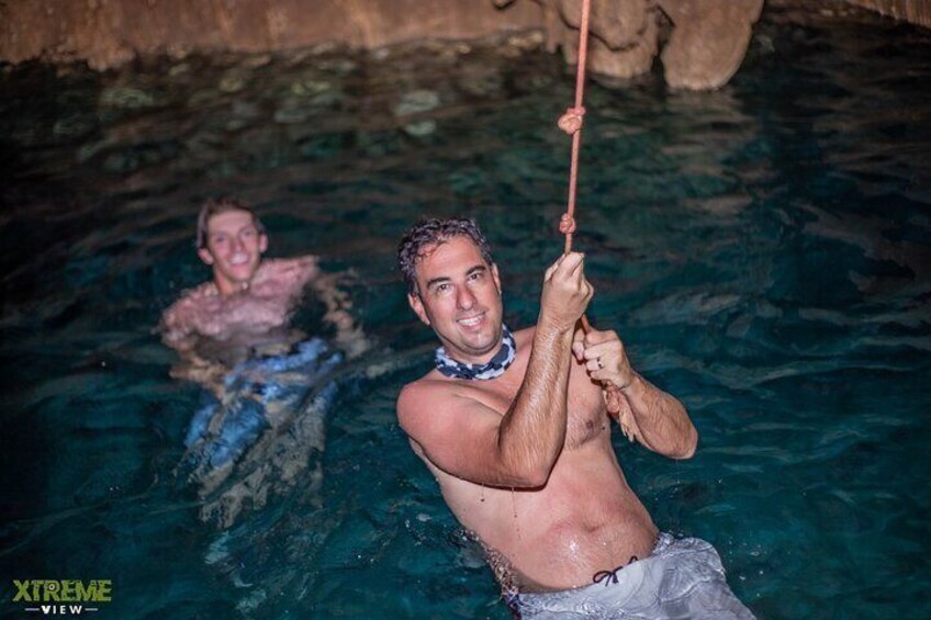 Two people in a swimming pool, one holding a rope. 5