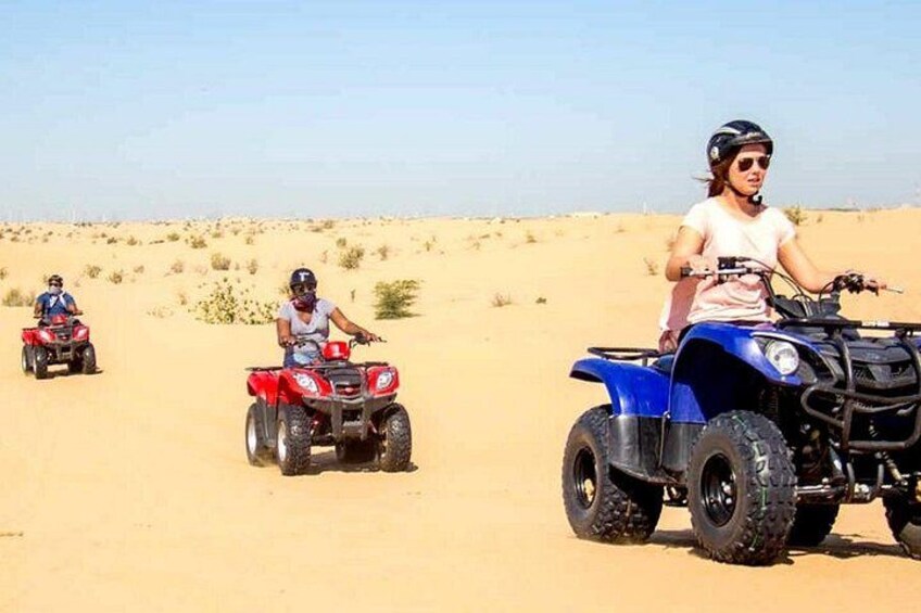 Three off-road vehicles on a sandy terrain with sparse vegetation. 1