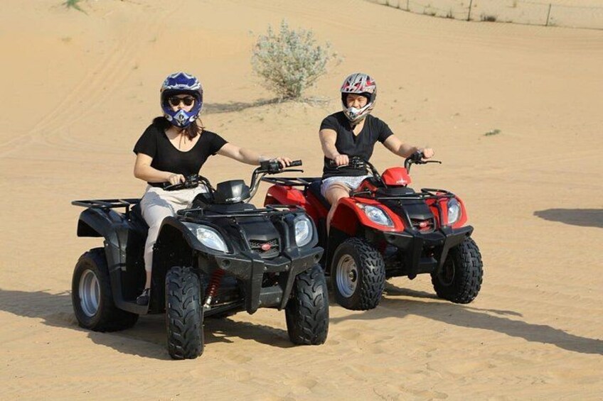 Two people on quad bikes in a desert landscape. 5