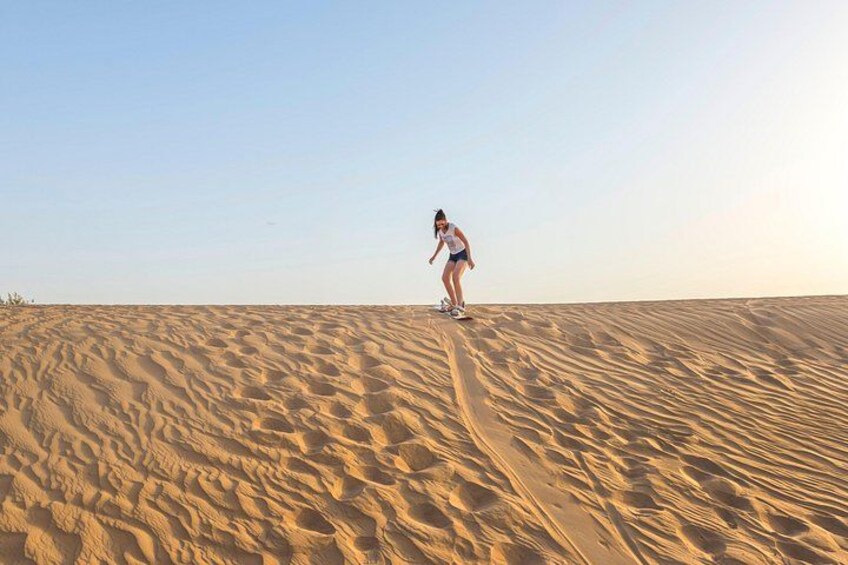 A person riding a skateboard on a sandy dune. 2