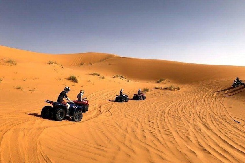 A desert landscape with sand dunes and off-road vehicles. 4
