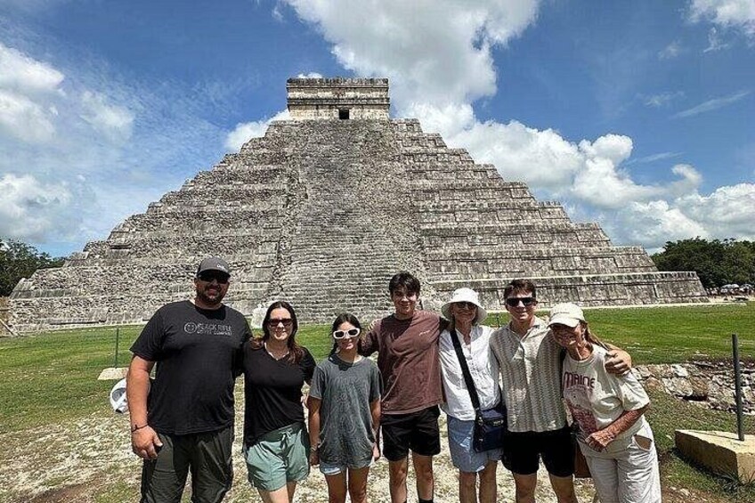A group of people standing in front of a large pyramid-like structure. 4