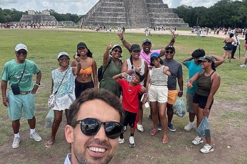A group of people standing in front of a large pyramid-like structure. 2