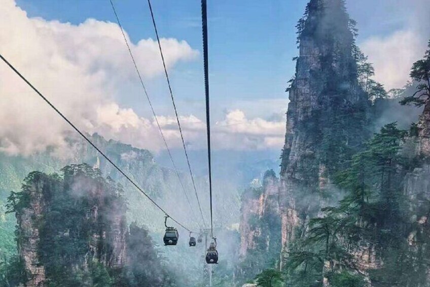 A cable car system in a mountainous area with steep cliffs and dense forests. 4
