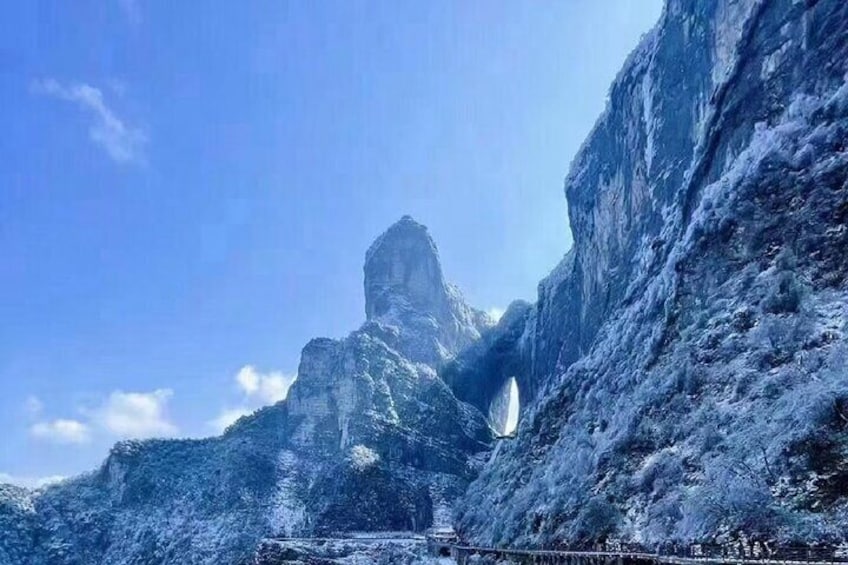 A mountainous landscape with a prominent rock formation and a narrow passageway. 1