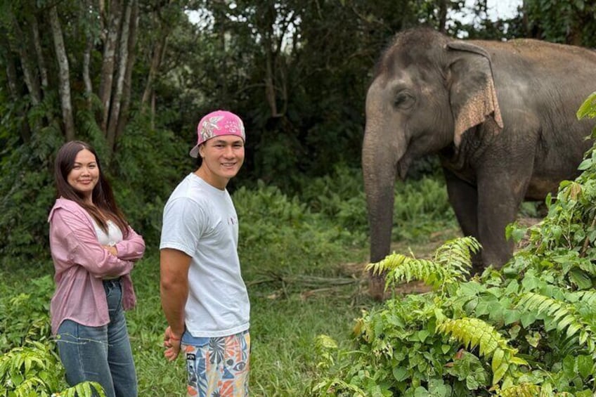 Een man en een vrouw staan in de buurt van een olifant in een bebost gebied. 1