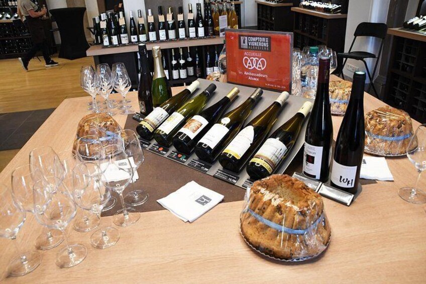 A wine tasting event with various bottles and glasses on a wooden table. 2