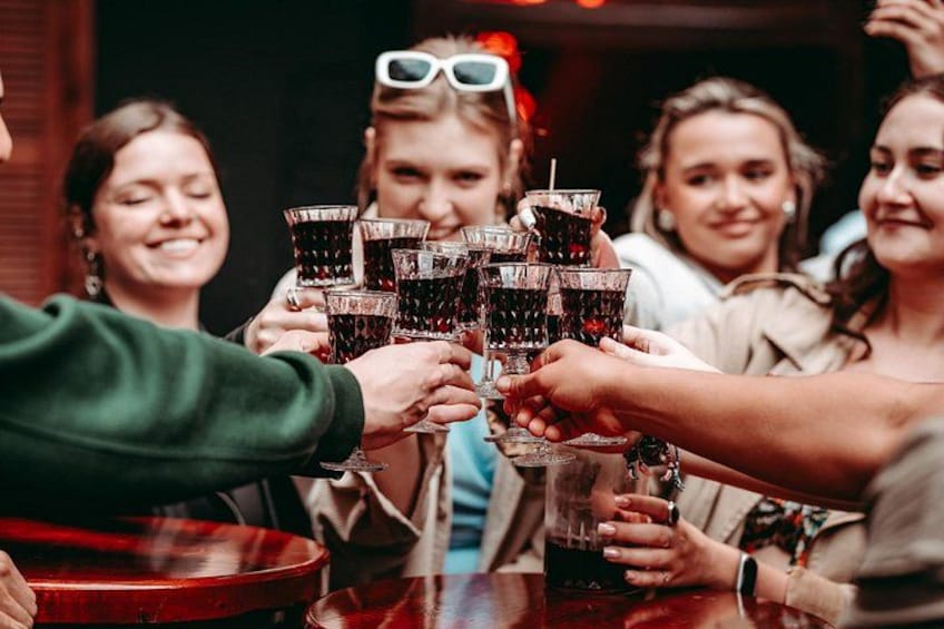 A group of people toasting with drinks at a table. 1