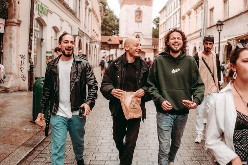 A group of people walking on a cobblestone street in an urban area with historic buildings. 2
