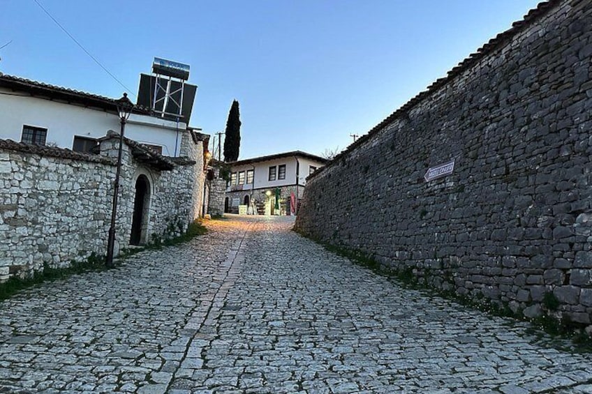 Una strada acciottolata fiancheggiata da muri e edifici in pietra. 4