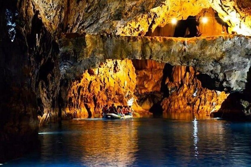 Eine Höhle mit einem Boot auf dem Wasser darin. 1