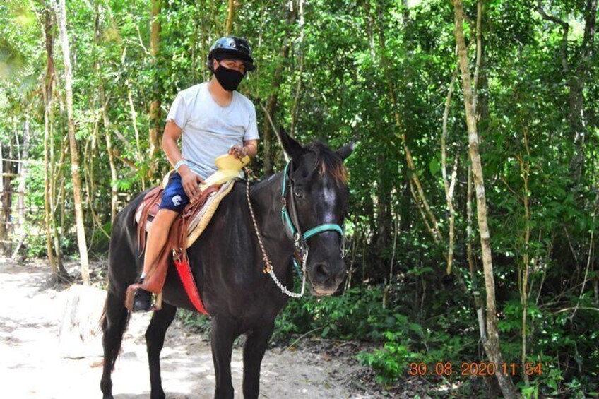 A person riding a horse through a forested area. 2