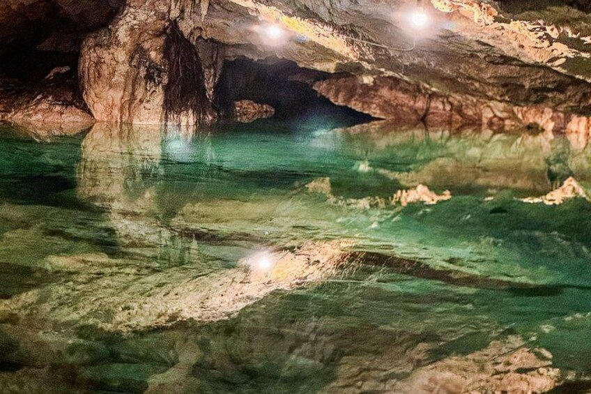 A cave with clear water and rock formations. 4