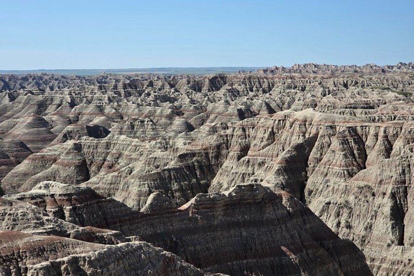 A vast landscape of eroded badlands with layered rock formations. 2