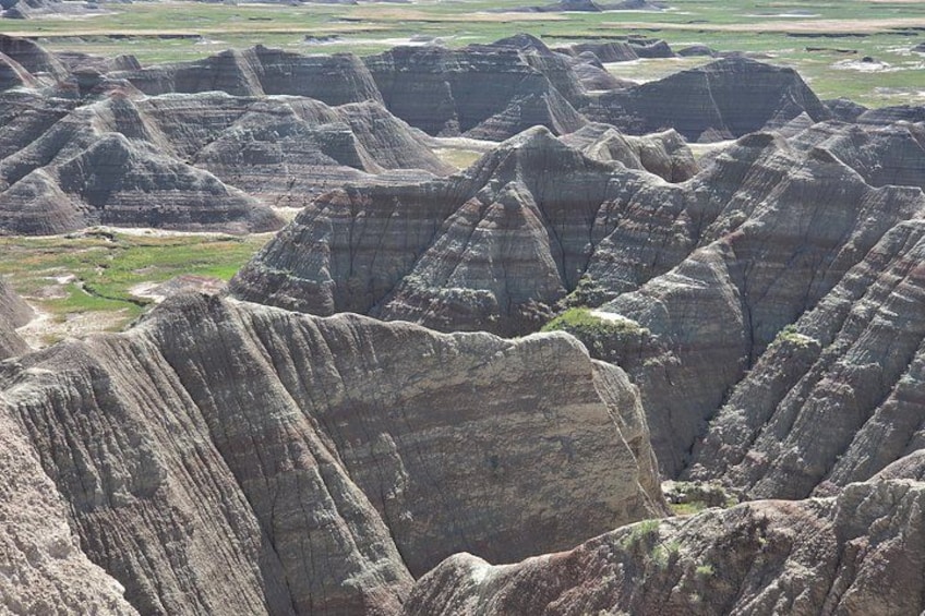 A landscape of rugged badlands with eroded hills and valleys. 5