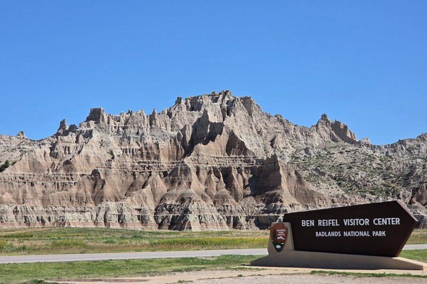 A sign for the Ben Reifel Visitor Center at Badlands National Park with a rugged mountain backdrop. 4