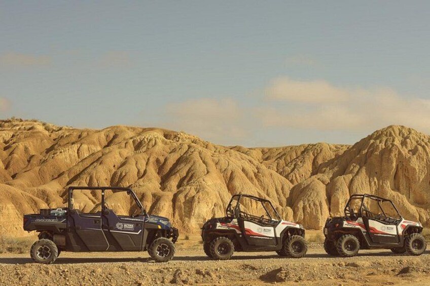 Two off-road vehicles in a desert landscape with rugged terrain. 2