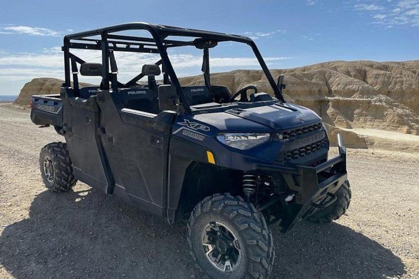 A Polaris XDP off-road vehicle parked on a gravel road with desert terrain in the background. 3