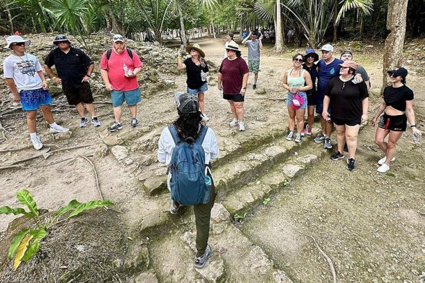 Un grupo de personas caminando por un sendero rocoso rodeado de vegetación tropical. 3