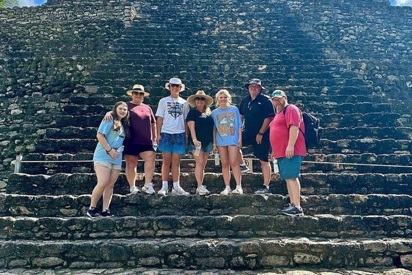 Un grupo de personas de pie sobre escalones de piedra antiguos. 2