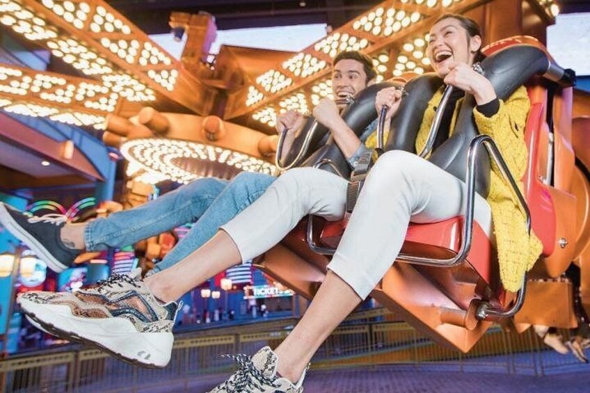 A roller coaster with passengers seated and holding onto the bars. 1