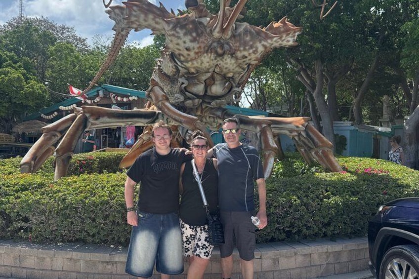Two people standing in front of a large sculpture of a crab. 4