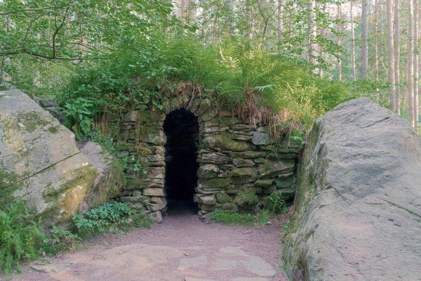 A stone tunnel entrance surrounded by greenery. 2