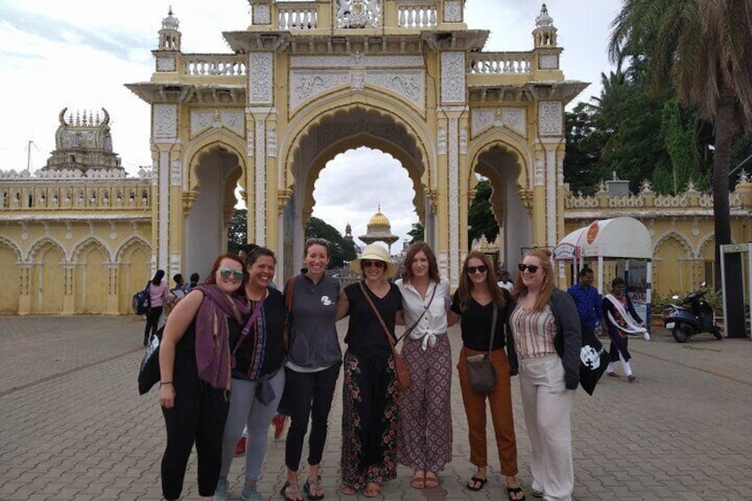 A group of people standing in front of a large, ornate archway with intricate designs and a domed structure in the background. 5