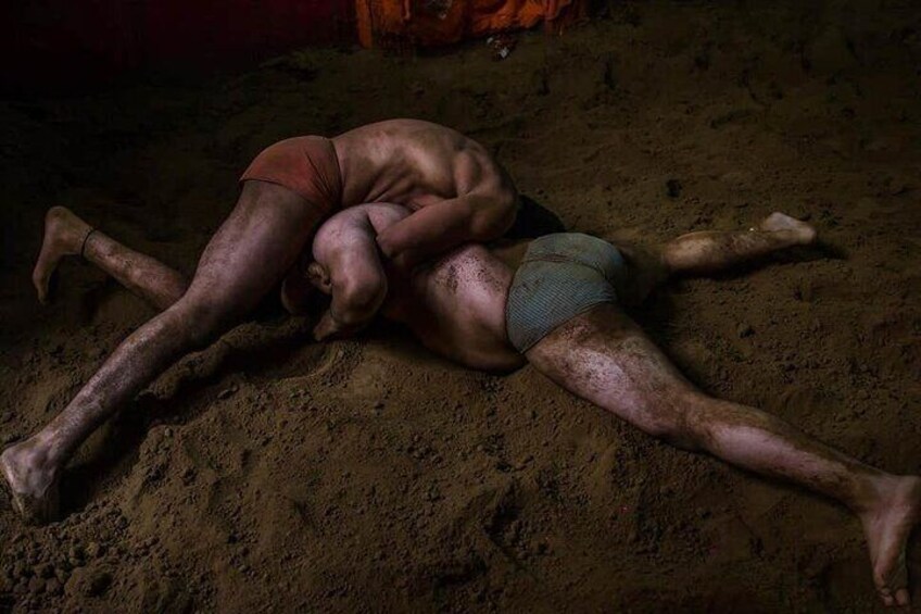 Two people lying on the ground in a sandy area. 3
