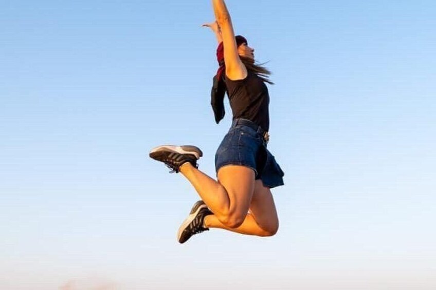 A person jumping in mid-air against a clear sky. 4